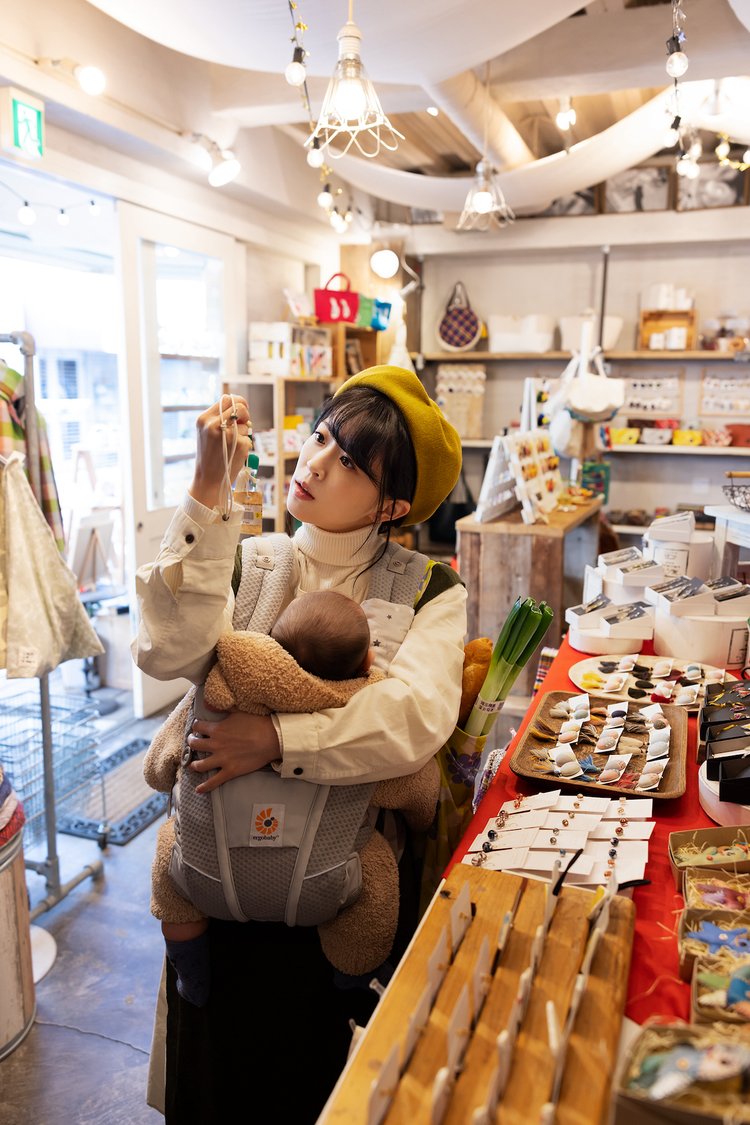 子供を抱っこしながら買い物を楽しむ女性