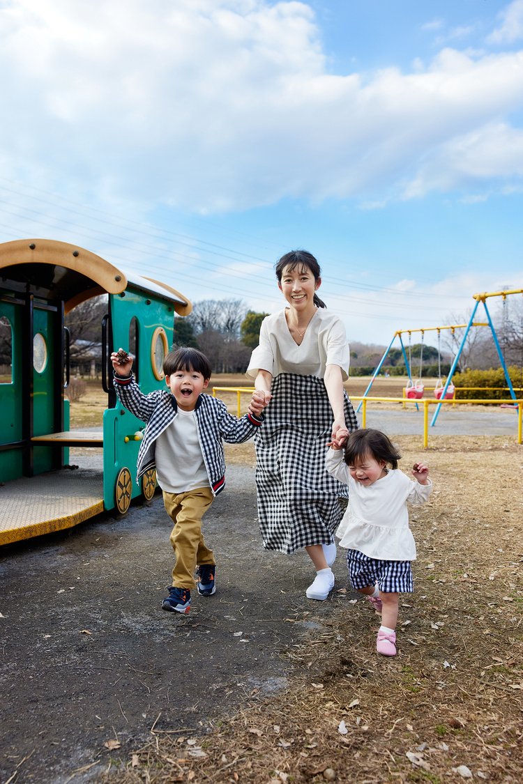 二人の子供と手を繋いで走る女性