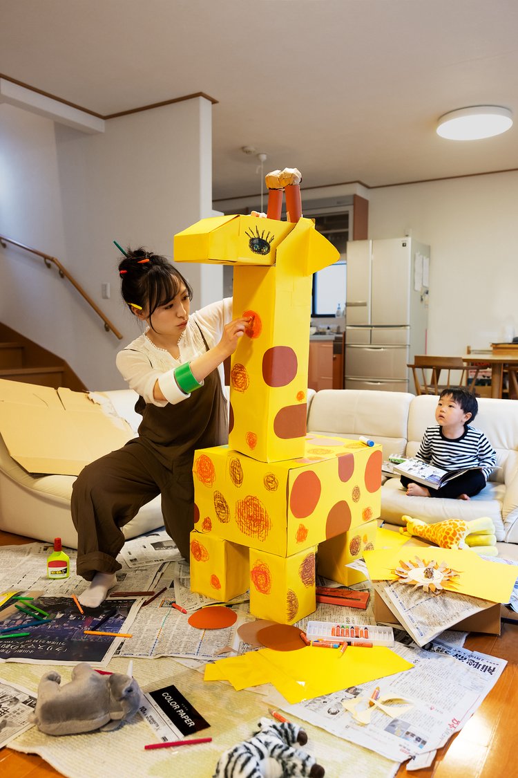 子供のために段ボールでキリンを作る母