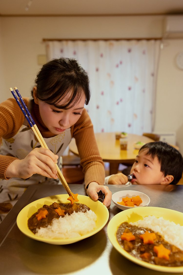 子供とカレーの盛り付けをする母